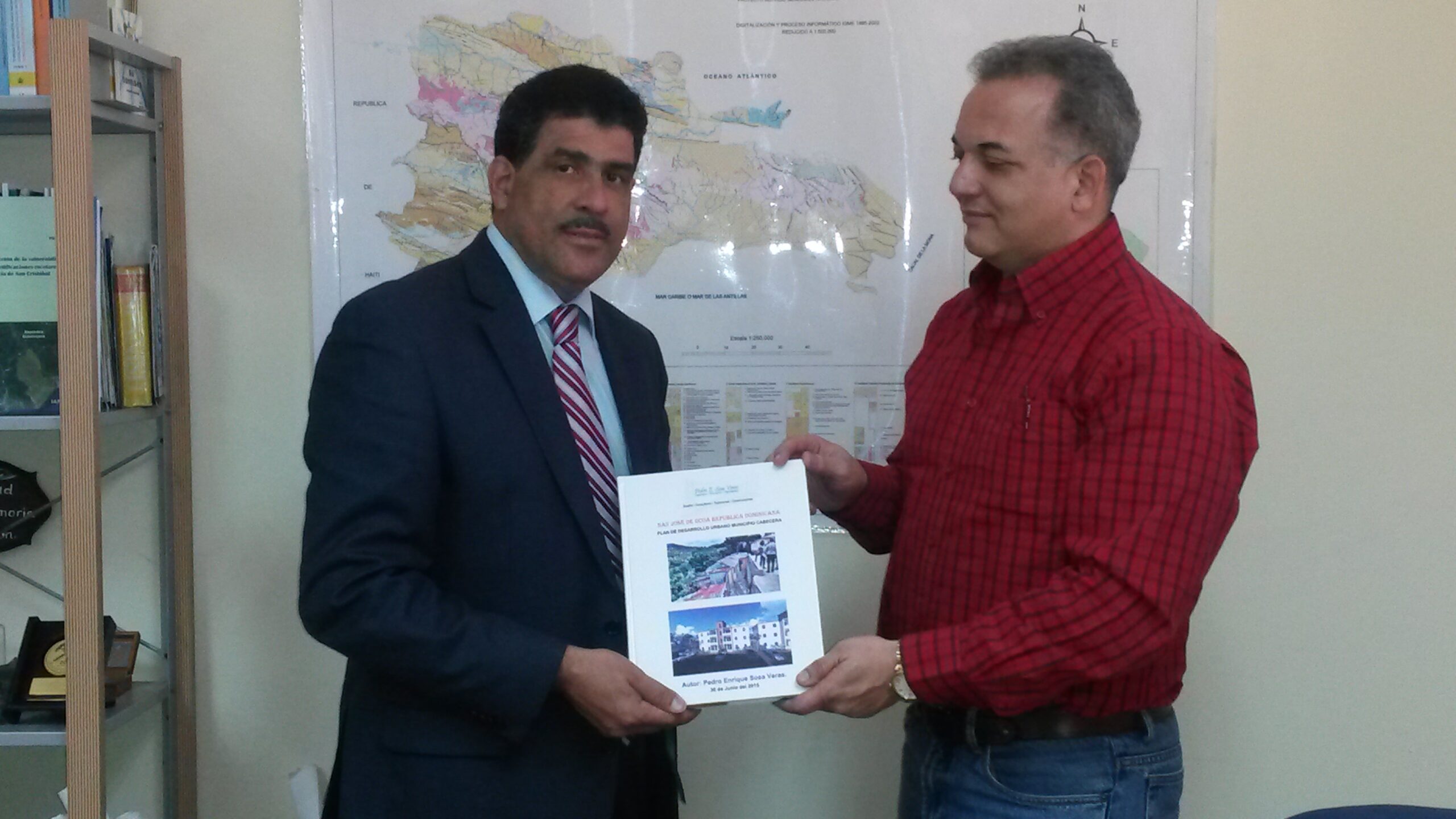 El Ing. Santiago Muñoz, Director del Servicio Geológico Nacional, recibe del Ing. Arq. Pedro E. Sosa V. un ejemplar del Plan de Desarrollo Urbano de San José de Ocoa