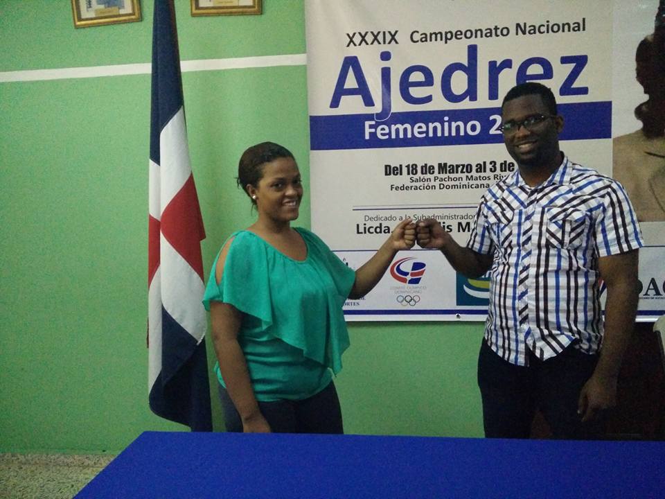 Carlos del Rosario directivo de la Federación Dominicana deAajedrez felicita a la campeona nacional de ajedrez femenino Wilsaida Díaz.