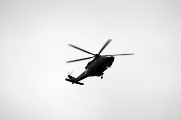 monochrome photo of flying helicopter