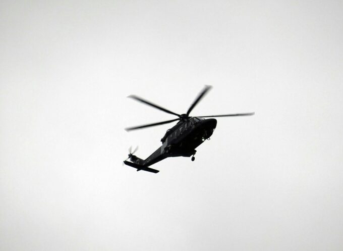 monochrome photo of flying helicopter